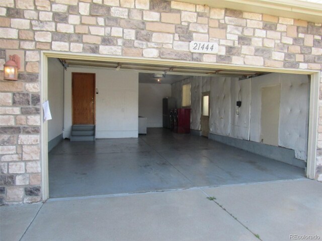 garage with concrete driveway and a garage door opener