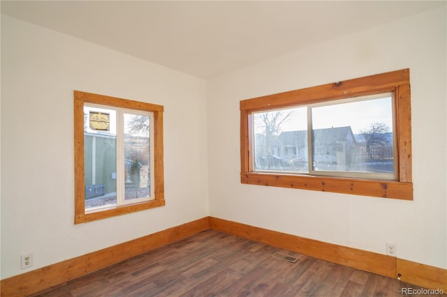 unfurnished room with dark wood-type flooring