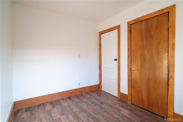 unfurnished bedroom with dark hardwood / wood-style floors and a closet