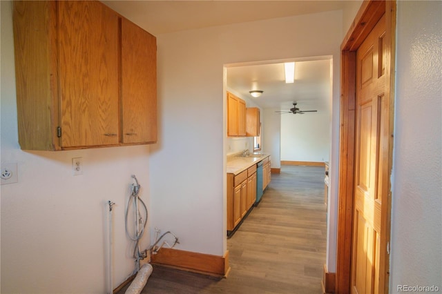 interior space featuring stainless steel dishwasher, ceiling fan, light hardwood / wood-style floors, and sink