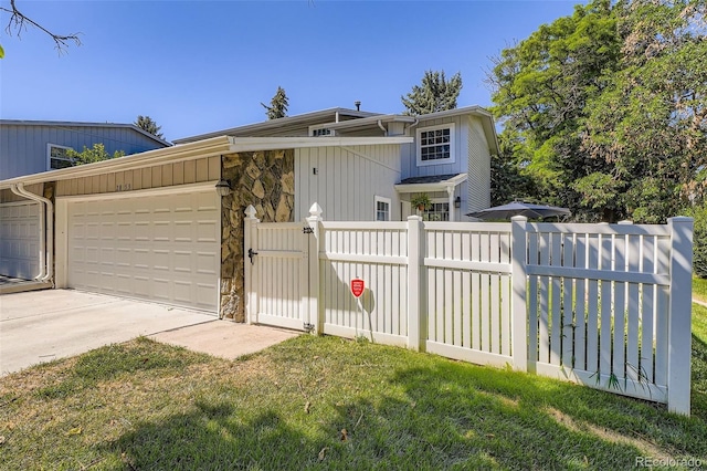2853 S Xanadu Way, Aurora, CO 80014 - view of front of home with an attached garage, a gate, concrete driveway, and stone siding