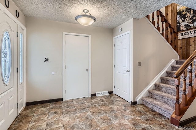2853 S Xanadu Way, Aurora, CO 80014 - entrance foyer featuring stairway, stone finish flooring, and a textured ceiling