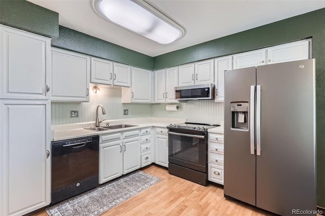 2853 S Xanadu Way, Aurora, CO 80014 - kitchen with stainless steel appliances, light wood-style floors, white cabinetry, and light countertops