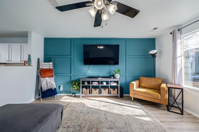 living room featuring light hardwood / wood-style floors and ceiling fan