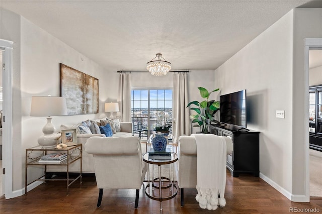 living room with baseboards, a textured ceiling, an inviting chandelier, and wood finished floors