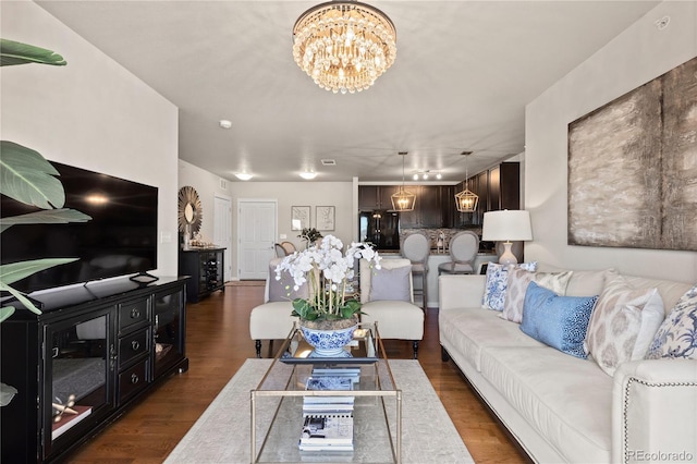 living room with dark wood finished floors and an inviting chandelier