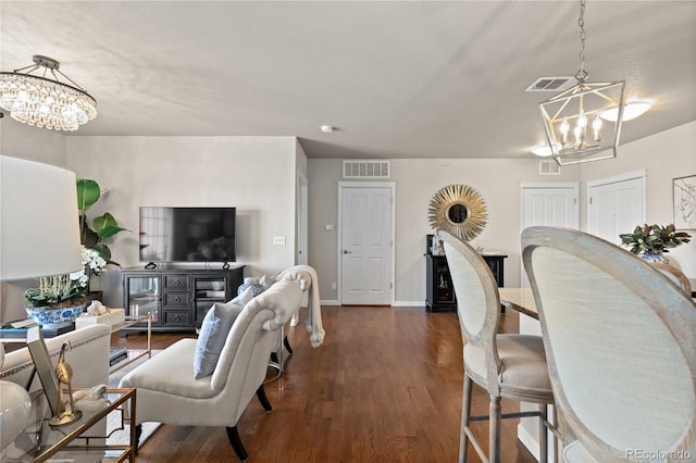 living room with a chandelier, visible vents, and dark wood finished floors