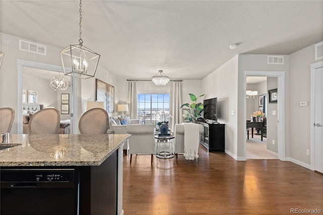 kitchen with visible vents, dishwasher, dark wood-type flooring, and an inviting chandelier