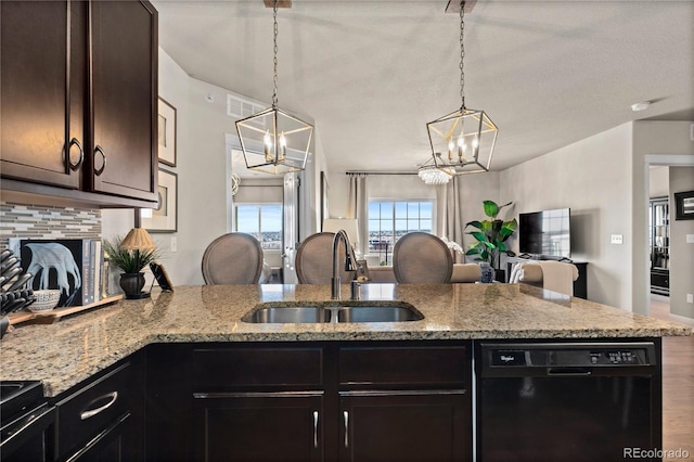 kitchen with visible vents, a sink, black dishwasher, backsplash, and a chandelier