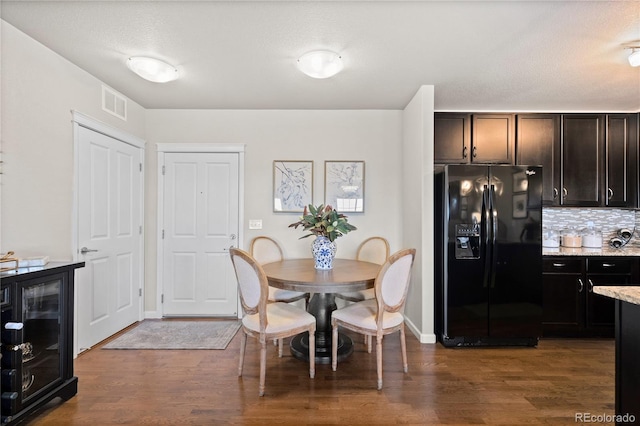 dining space with visible vents, baseboards, and dark wood finished floors