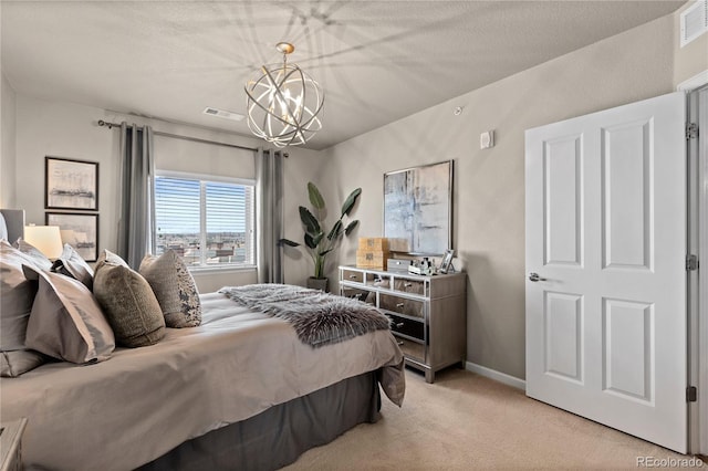 bedroom with an inviting chandelier, light colored carpet, baseboards, and visible vents