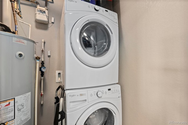 laundry area with gas water heater, stacked washer / dryer, a textured wall, and laundry area