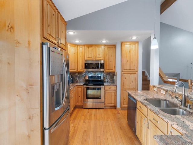 19093 W 61st Pl, Golden, CO 80403 - kitchen featuring a sink, light wood-style flooring, backsplash, lofted ceiling, and appliances with stainless steel finishes