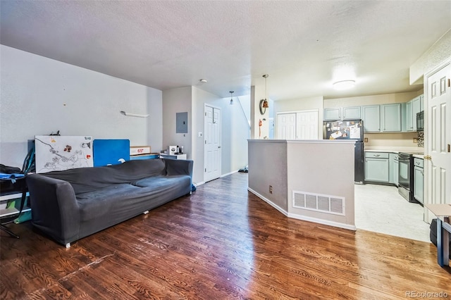 living room featuring a textured ceiling, electric panel, and dark hardwood / wood-style floors