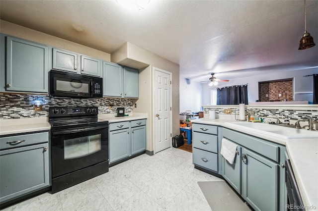 kitchen with backsplash, black appliances, sink, hanging light fixtures, and ceiling fan