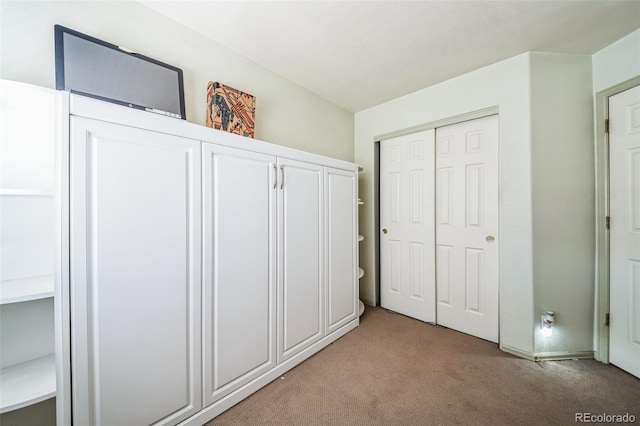 unfurnished bedroom with light carpet and a closet