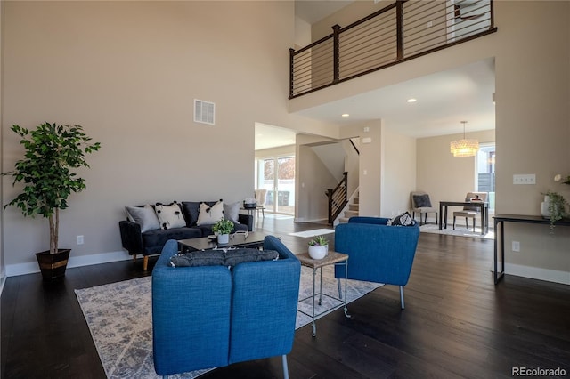 living room featuring wood finished floors, visible vents, and baseboards