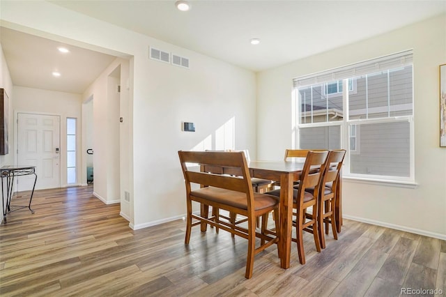 dining area with visible vents, plenty of natural light, and wood finished floors