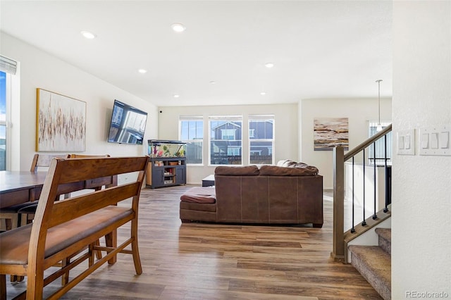 living room featuring recessed lighting, wood finished floors, and stairs