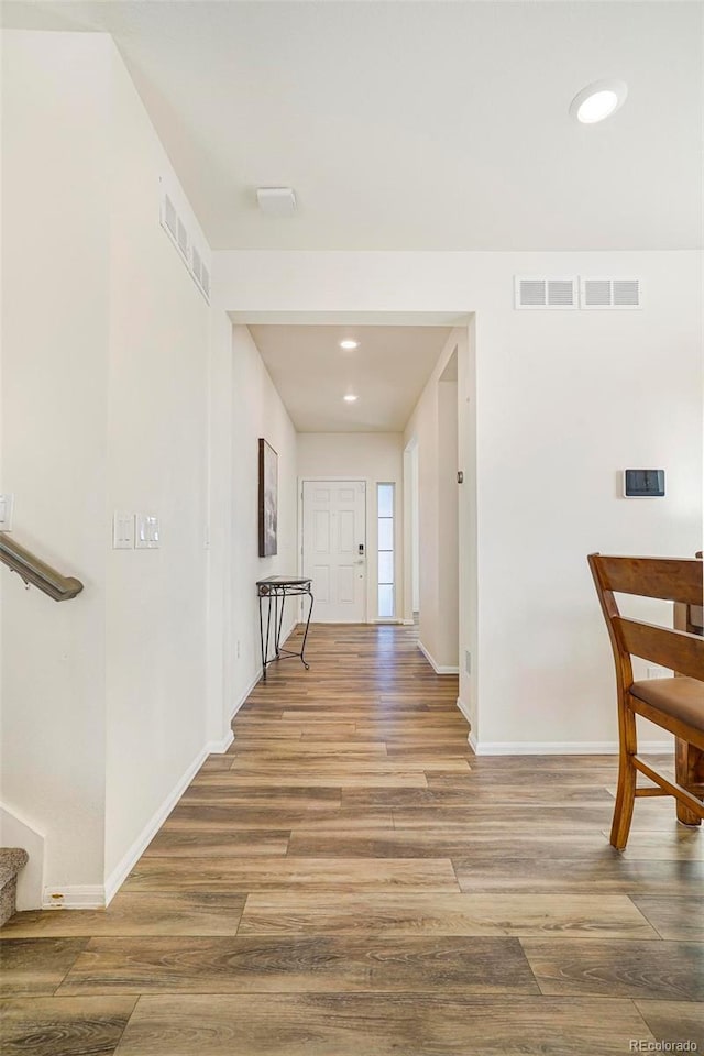 corridor with recessed lighting, visible vents, stairway, wood finished floors, and baseboards