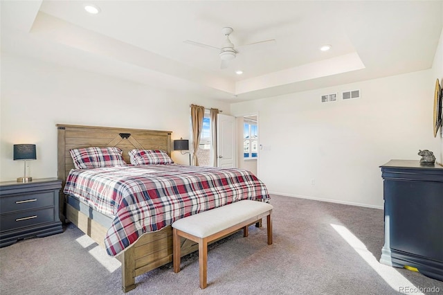 bedroom featuring visible vents, baseboards, a raised ceiling, a ceiling fan, and carpet floors