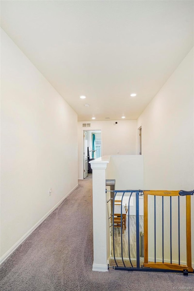 hallway featuring baseboards, recessed lighting, an upstairs landing, and light colored carpet