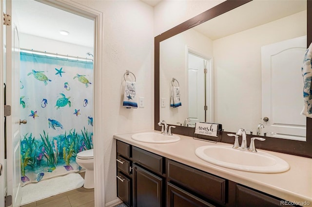 full bath with double vanity, a shower with shower curtain, a sink, and toilet