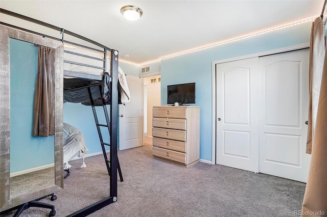 carpeted bedroom with visible vents and a closet