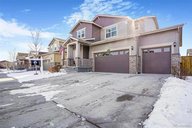 view of front of home with a garage, stone siding, driveway, and fence