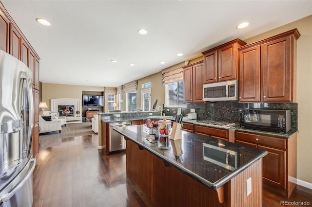 26764 E Canyon Ave, Aurora, CO 80016 - kitchen featuring appliances with stainless steel finishes, a peninsula, open floor plan, dark wood finished floors, and a sink