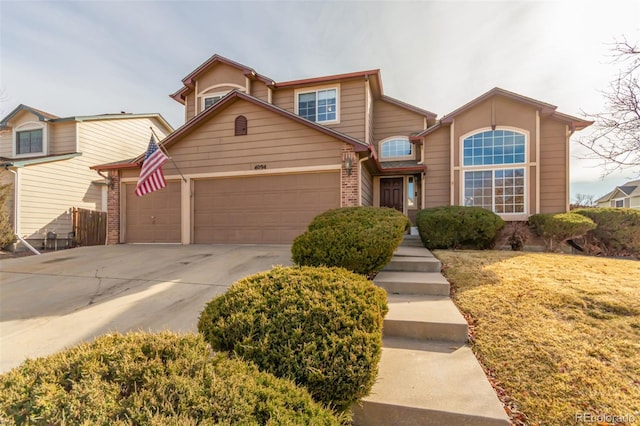 traditional-style house featuring concrete driveway, an attached garage, and brick siding