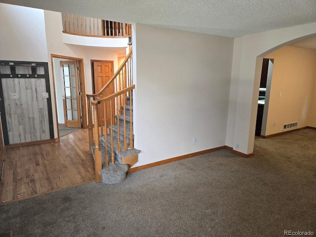 21064 E Crestline Cir, Centennial, CO 80015 - foyer entrance featuring arched walkways, carpet flooring, baseboards, stairs, and a textured ceiling