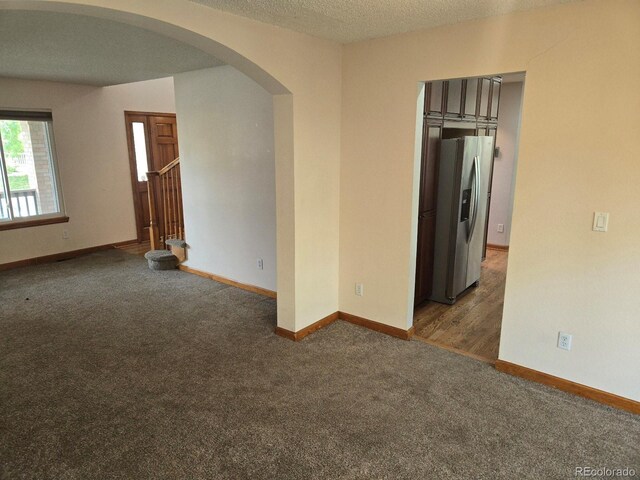 21064 E Crestline Cir, Centennial, CO 80015 - spare room with arched walkways, carpet floors, baseboards, and a textured ceiling