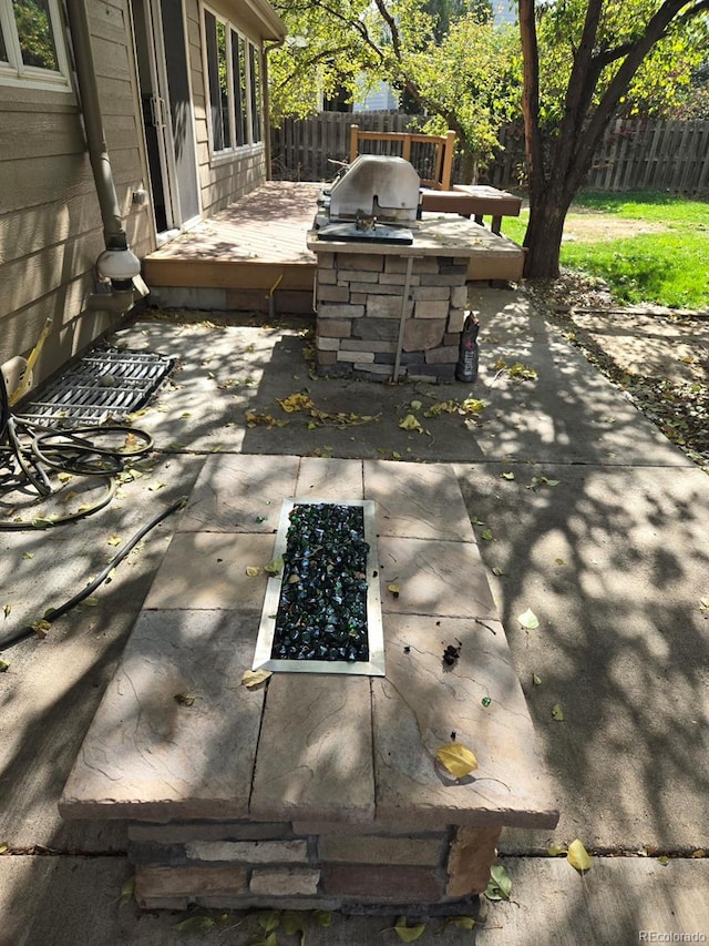 view of patio featuring an outdoor kitchen and a wooden deck