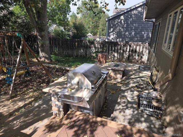 view of patio / terrace with a playground, a grill, and exterior kitchen