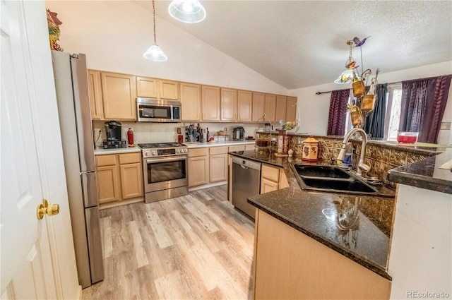kitchen with light wood-type flooring, light brown cabinetry, a sink, decorative light fixtures, and appliances with stainless steel finishes