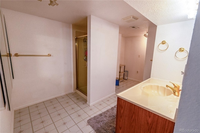 bathroom featuring vanity, baseboards, visible vents, a shower stall, and a textured ceiling