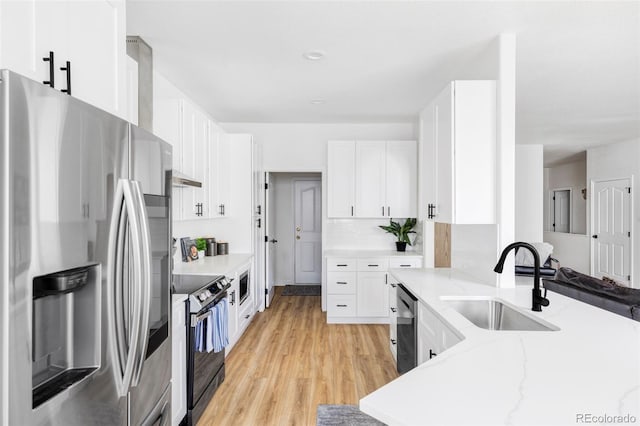 kitchen featuring sink, stainless steel appliances, light stone countertops, light hardwood / wood-style floors, and white cabinets