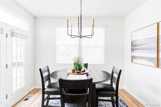 dining area with a chandelier and light wood-type flooring