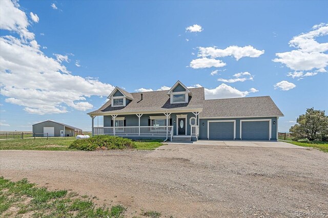 32800 E 137th Way, Brighton, CO 80603 - view of front of home featuring dirt driveway, a porch, an attached garage, and a shingled roof