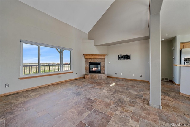 32800 E 137th Way, Brighton, CO 80603 - unfurnished living room featuring stone tile floors, baseboards, high vaulted ceiling, and a fireplace