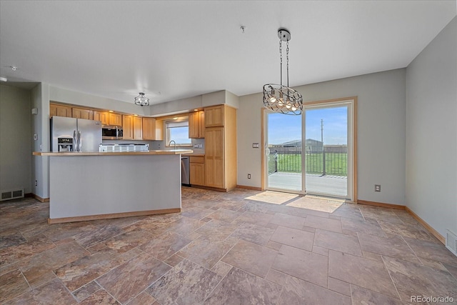32800 E 137th Way, Brighton, CO 80603 - kitchen featuring appliances with stainless steel finishes, baseboards, stone tile floors, a center island, and decorative light fixtures