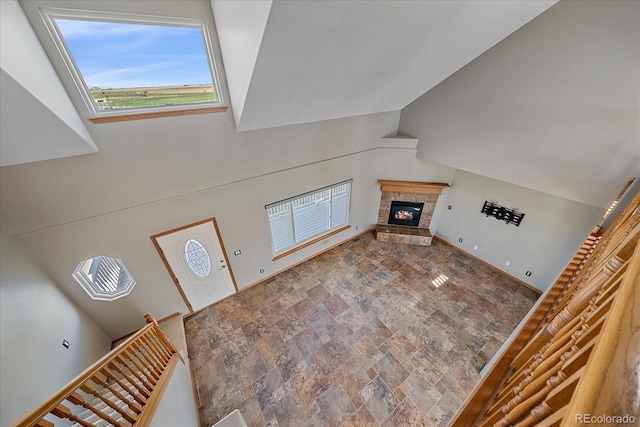 32800 E 137th Way, Brighton, CO 80603 - unfurnished living room featuring stone finish floors, a stone fireplace, and lofted ceiling