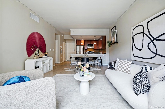 living area with light wood-style floors and baseboards