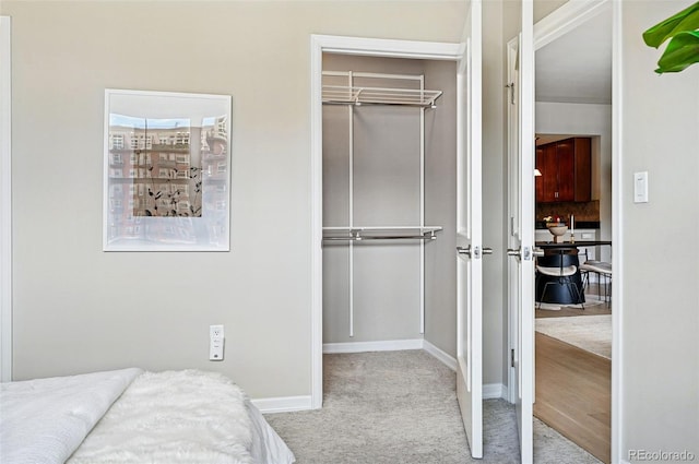 unfurnished bedroom with carpet, a closet, and baseboards