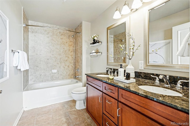 bathroom featuring toilet, tile patterned floors, double vanity, and washtub / shower combination