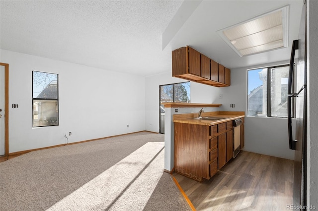 8701 Huron St Unit 5-210, Thornton, CO 80260 - kitchen featuring freestanding refrigerator, brown cabinetry, dishwasher, and light countertops