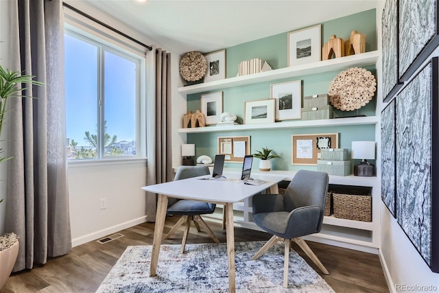 office area with wood finished floors, visible vents, and baseboards