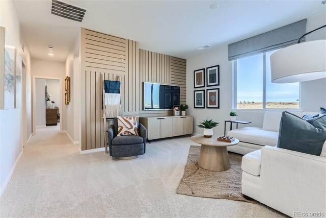 carpeted living area featuring baseboards and visible vents