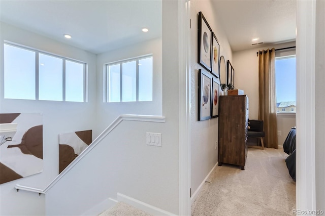 corridor with visible vents, an upstairs landing, recessed lighting, carpet flooring, and baseboards